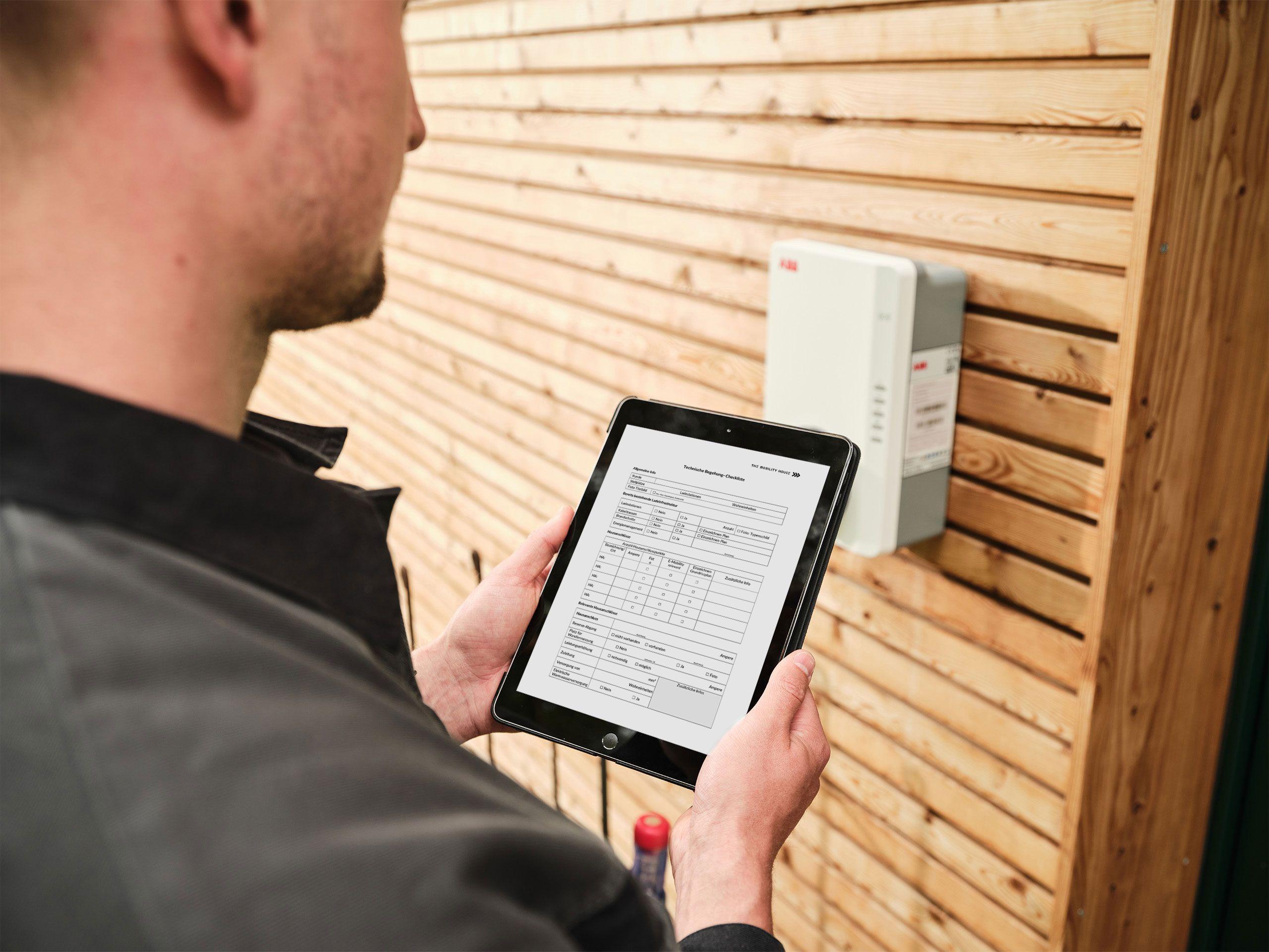 Elektriker mit Tablet an einer Ladestation