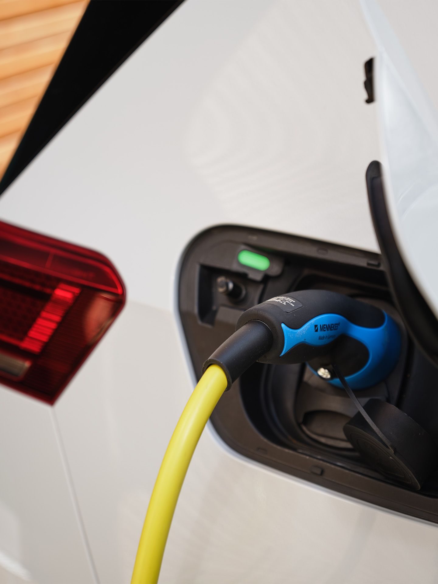 Ladebuchse eines Elektroautos mit angeschlossenem Ladekabel